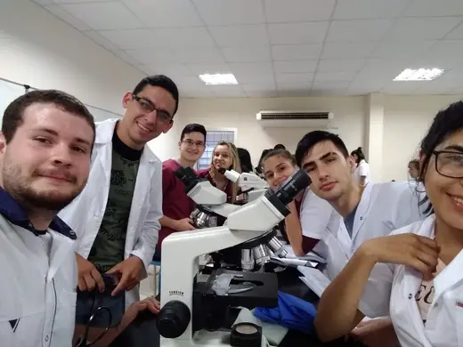 Grupo de estudiantes en una clase práctica con microscopios